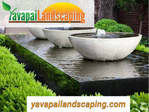 How do I create a serene water feature that adds tranquility to a beautifully landscaped outdoor space by Yavapai Landscaping?