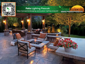 An inviting outdoor patio area at dusk with warm lighting, featuring comfortable seating, a fire pit, and vibrant greenery in the backdrop, advertising patio lighting services by yavapai landscaping.