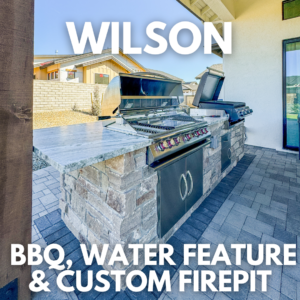 Outdoor kitchen with a built-in BBQ grill and granite countertop under a covered patio at the Wilson Residence. A brick water feature and custom firepit are also visible, with "Wilson BBQ, Water Feature & Custom Firepit" text overlaid. Modern house and backyard are in the background.