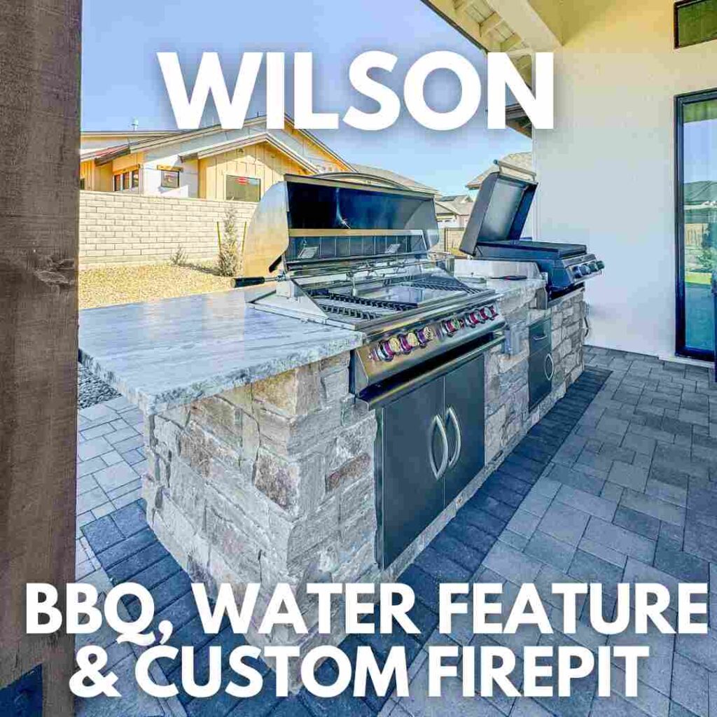 An outdoor kitchen features two barbecues, a marble countertop, and stone base on a brick patio with a tiled roof. Text reads "WILSON" at the top and "BBQ, WATER FEATURE & CUSTOM FIREPIT" below. This inviting space also enhances air quality while the water feature attracts wildlife.