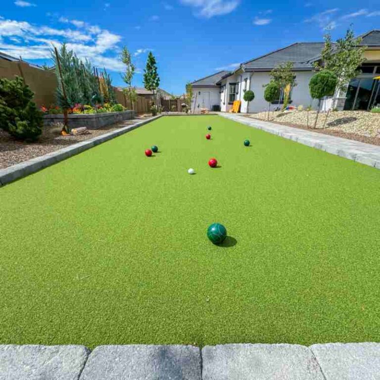 Artificial turf bowling green with colorful balls in a landscaped backyard, showcasing low-maintenance outdoor recreation options in Prescott Valley.