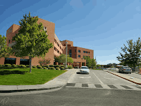 Building exterior with landscaped green areas and trees, showcasing a sunny day and clear blue sky, near Prescott, Arizona.